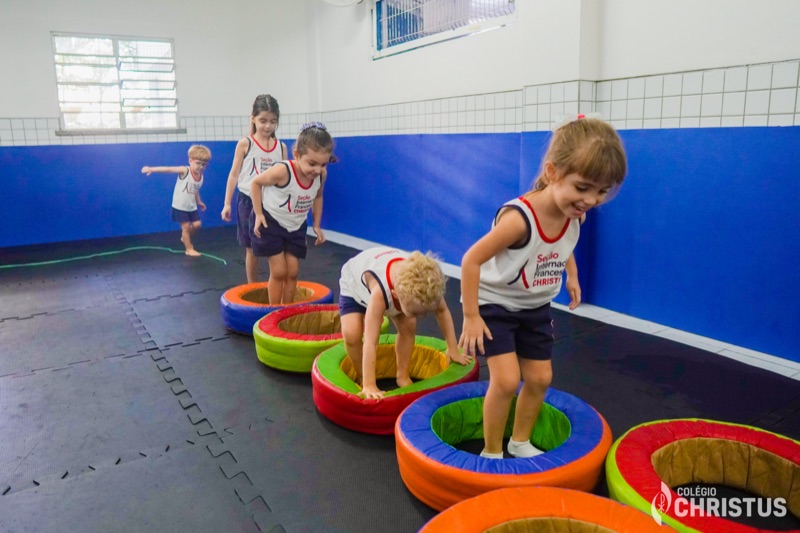 Crianças em circuito de atividades físicas na quadra